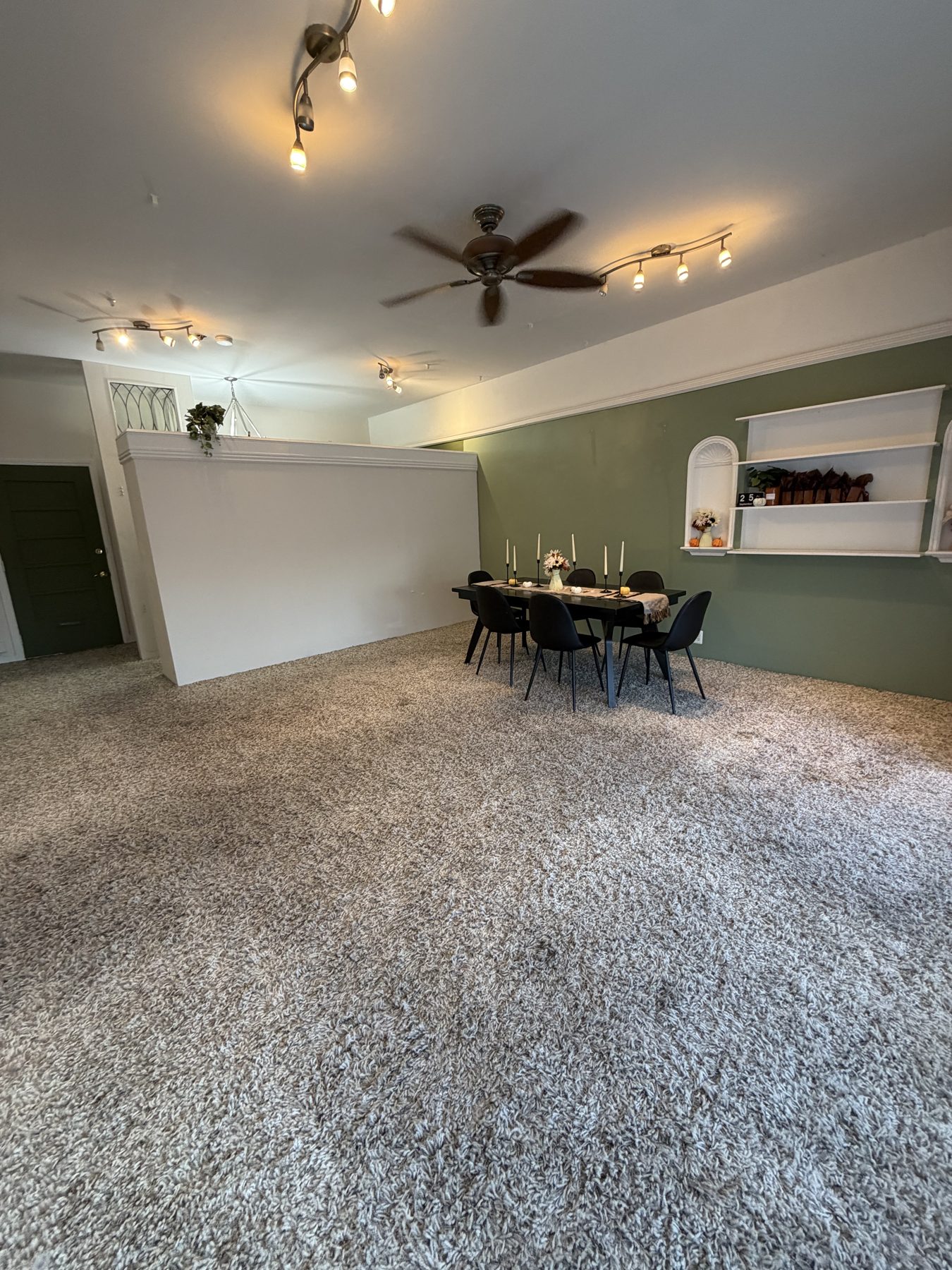 Sorelle Studio open room with green accent wall and black table